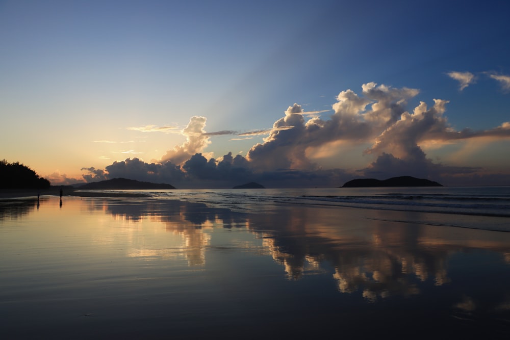 a person walking on a beach at sunset