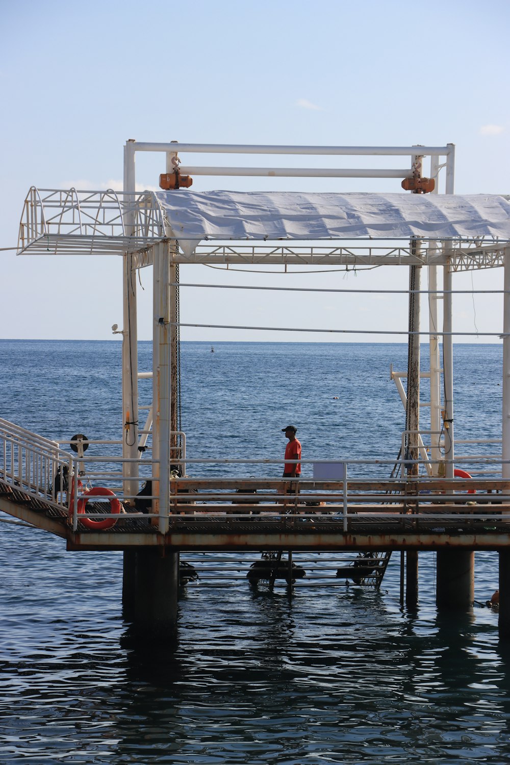 a man standing on a dock next to the ocean