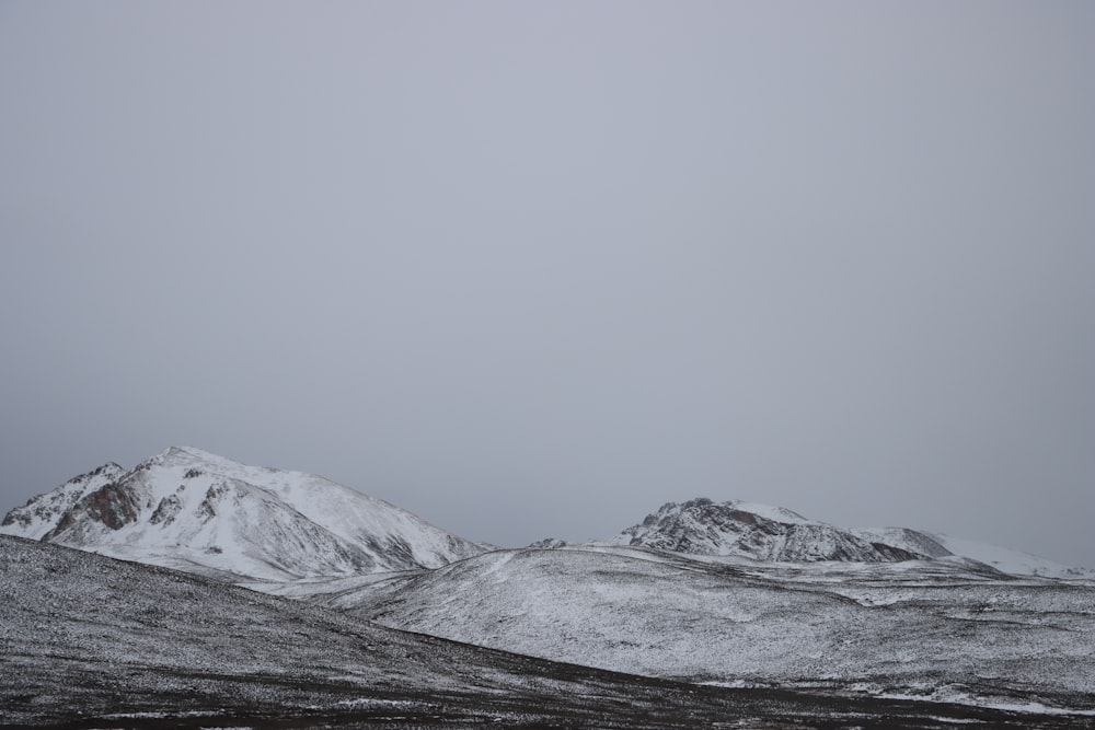 a mountain range covered in snow on a cloudy day