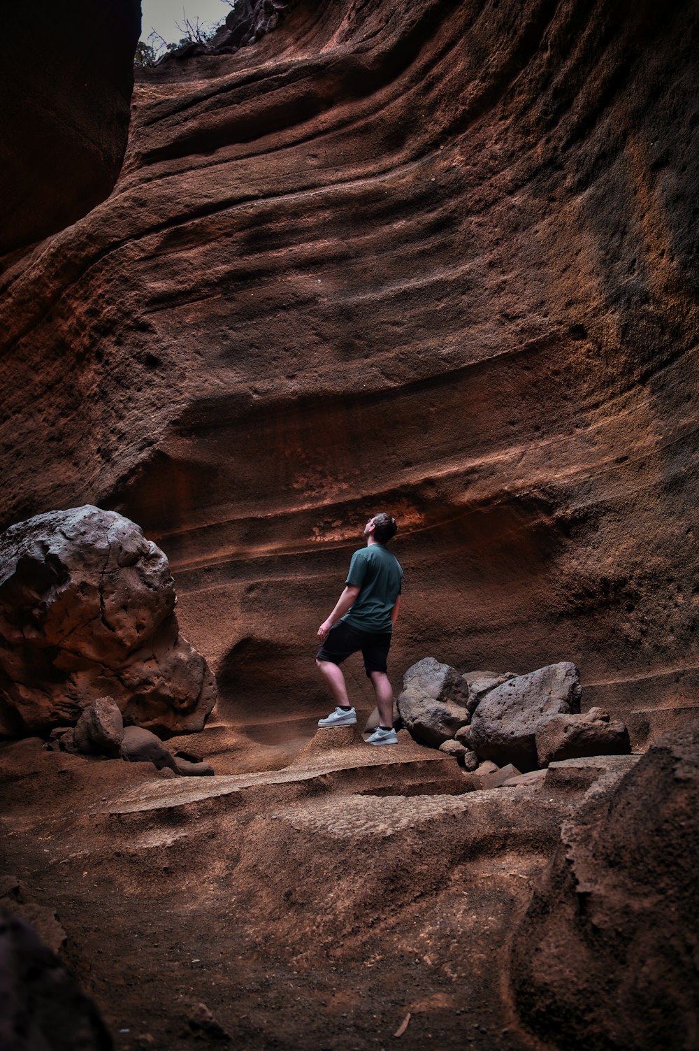 Un hombre de pie sobre una formación rocosa en un cañón