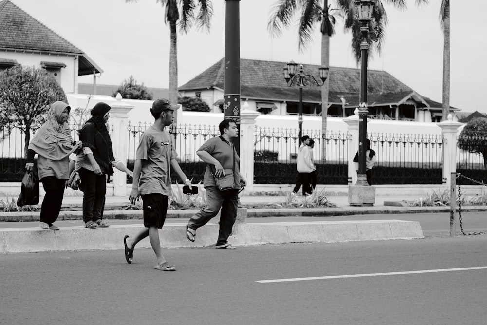 a group of people walking across a street