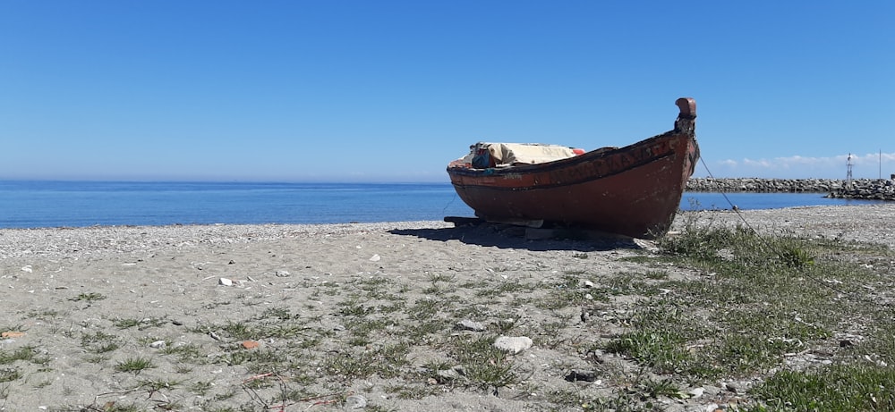 a boat sitting on top of a sandy beach