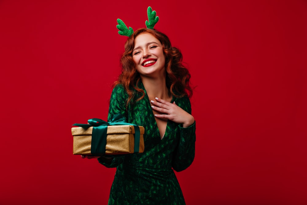 a woman in a green dress holding a present
