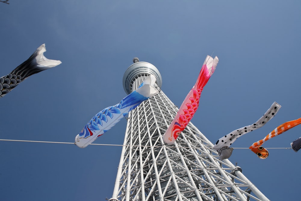 a very tall tower with a bunch of kites hanging from it's sides