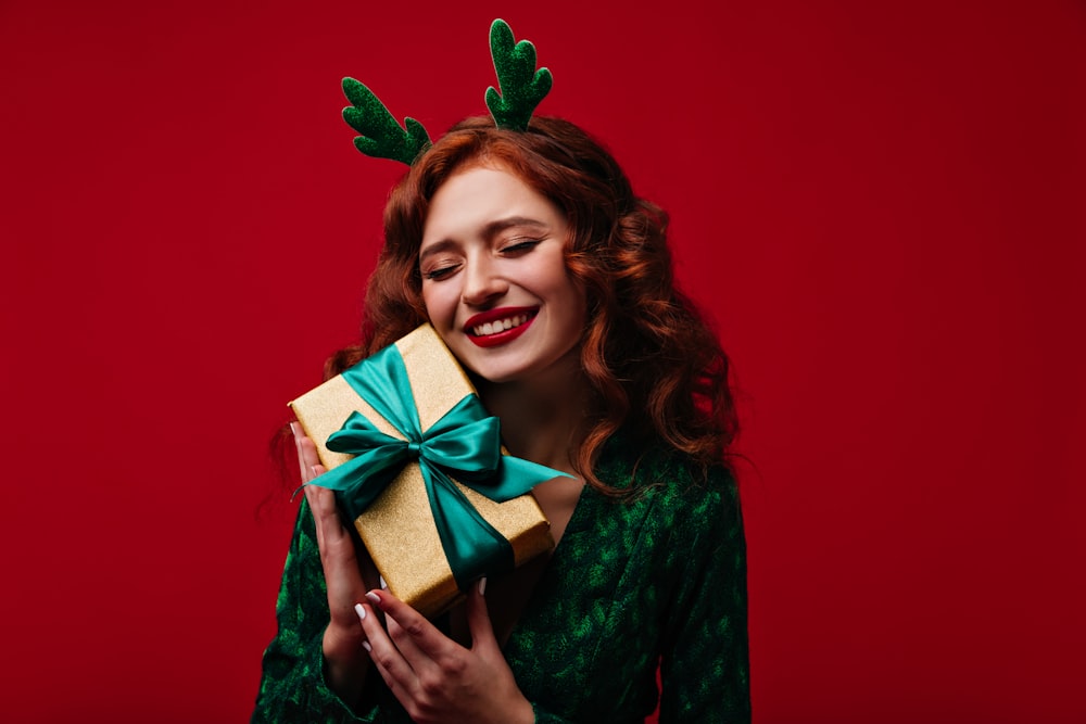 a woman in a green dress holding a present