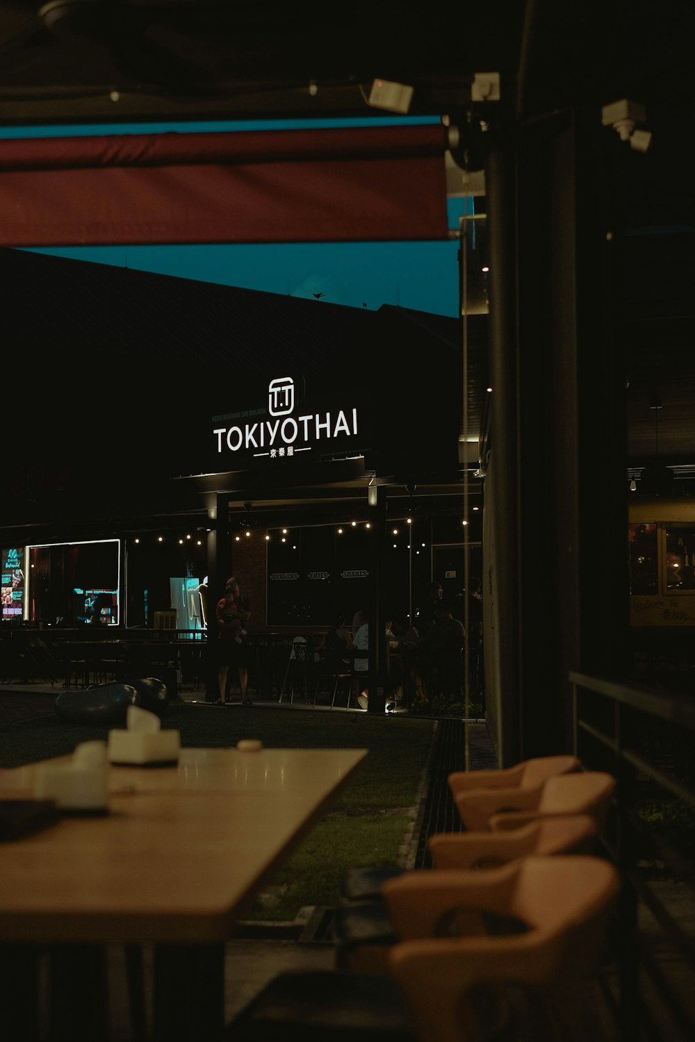 a restaurant with tables and chairs outside at night