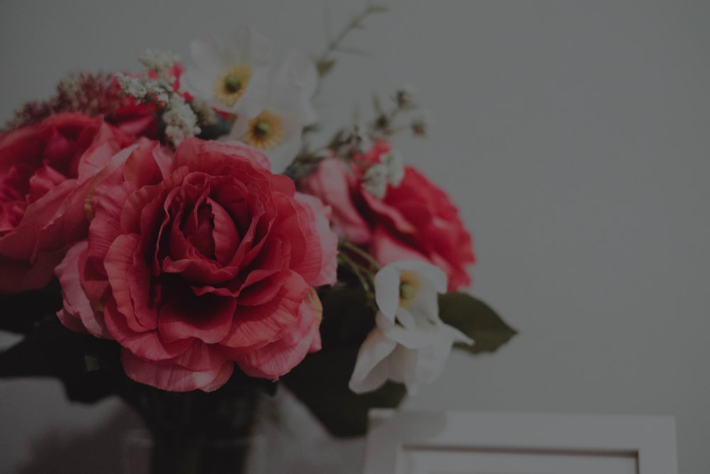 a vase filled with red and white flowers