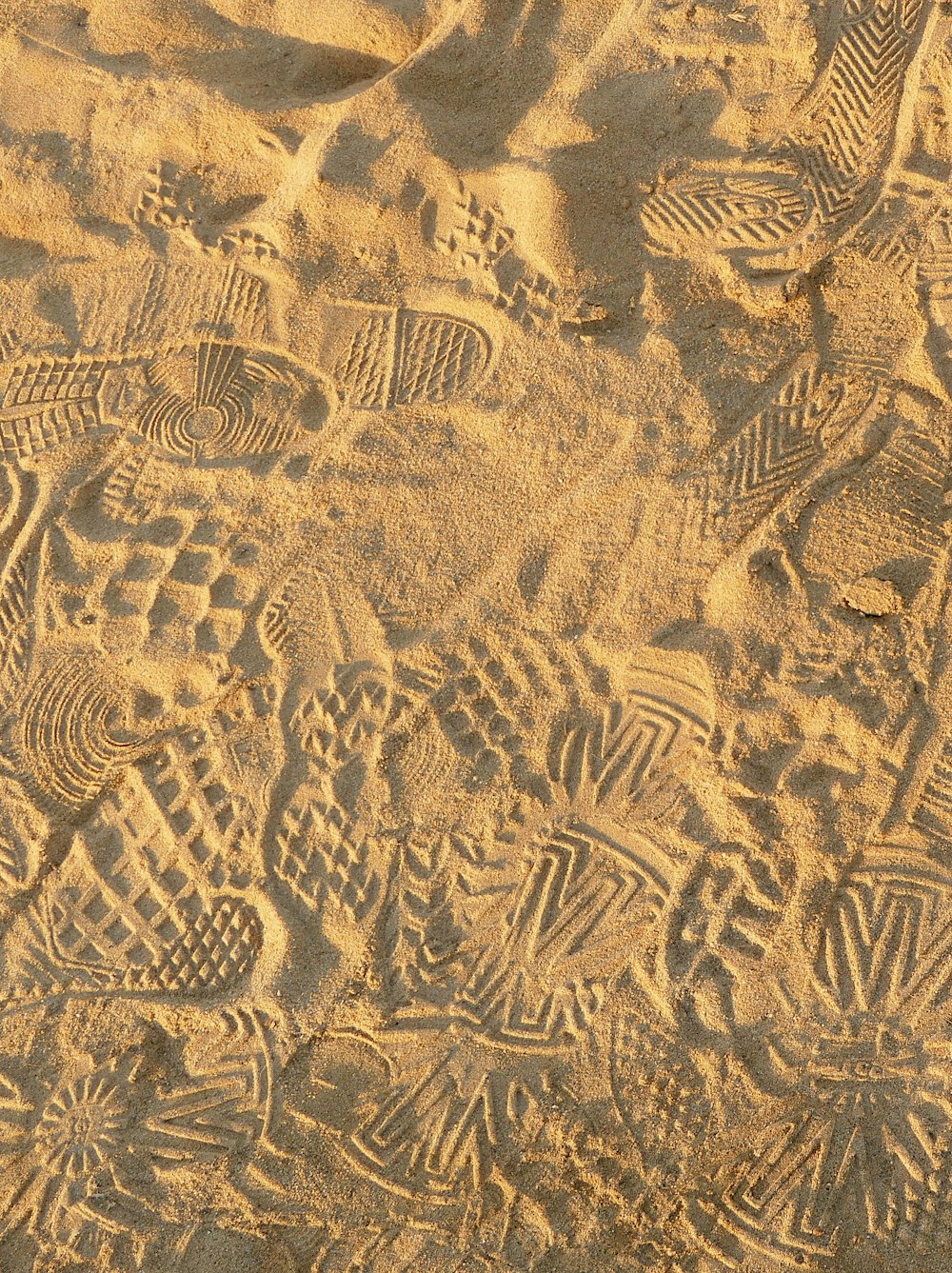 a close up of a sandy beach with footprints in the sand