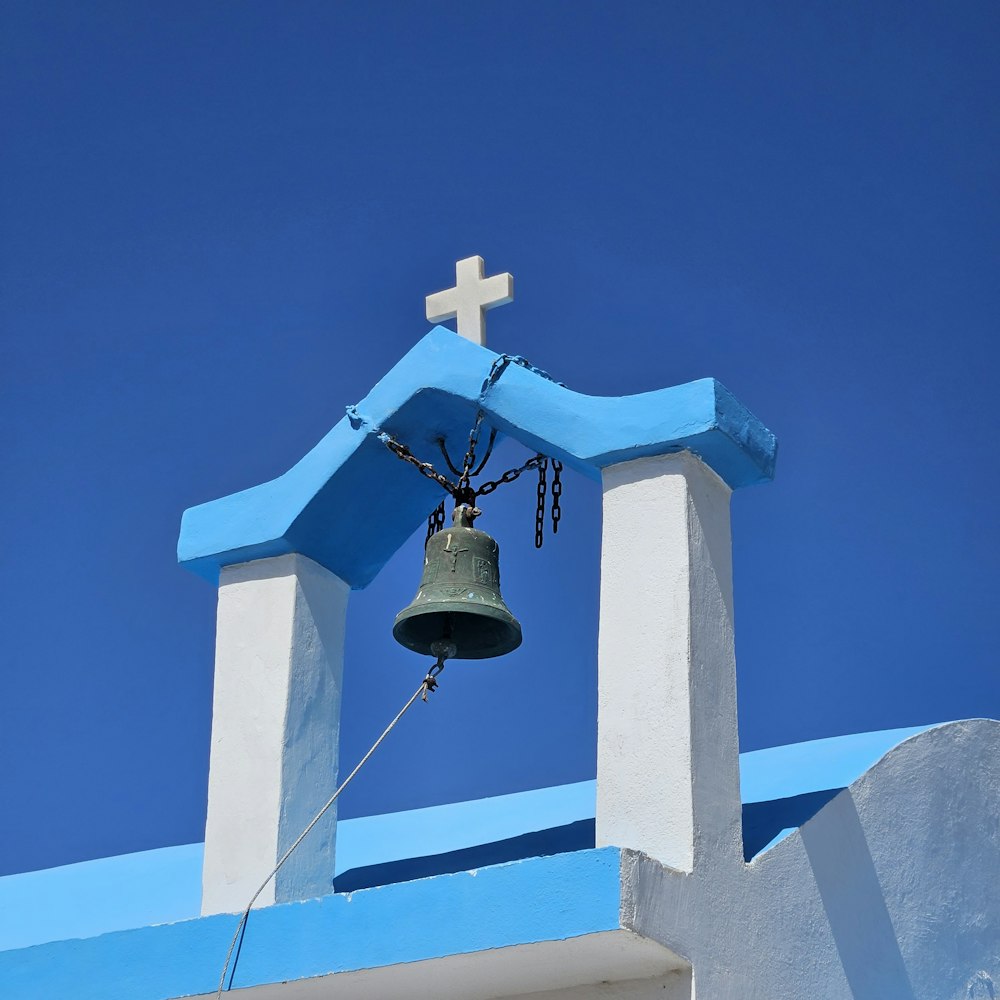 a bell with a cross on top of it