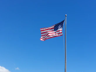 an american flag flying in the wind on a clear day