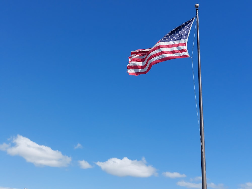 an american flag flying in the wind on a sunny day