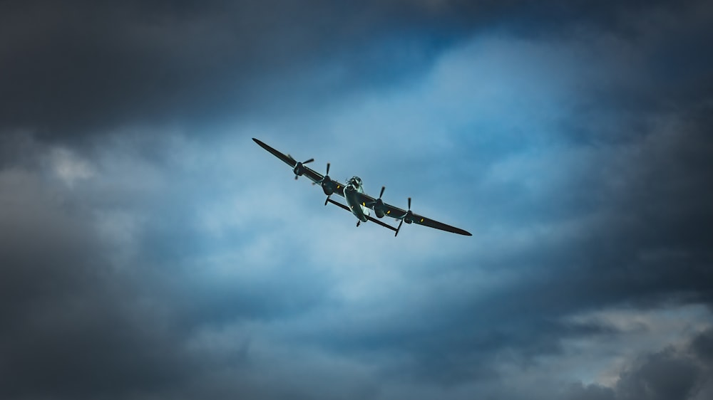 a plane flying through a cloudy sky on a cloudy day