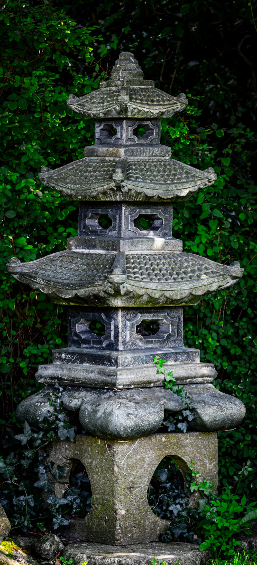 a tall stone tower sitting in the middle of a forest