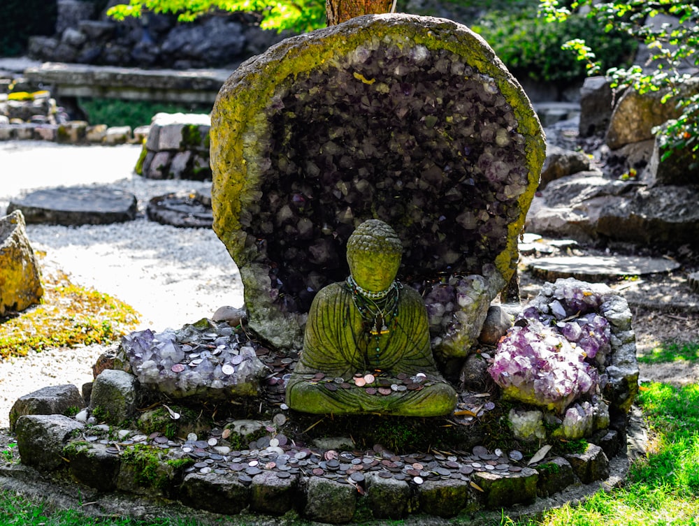 a buddha statue sitting in the middle of a garden