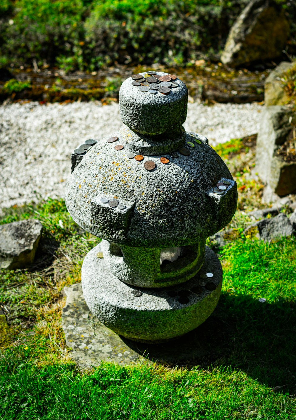a stone sculpture sitting on top of a lush green field