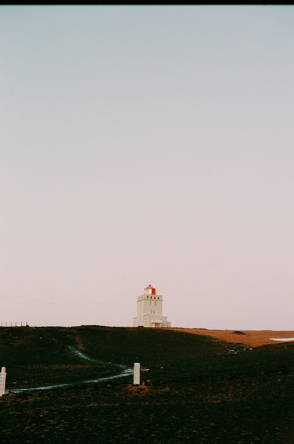 a white lighthouse on top of a hill