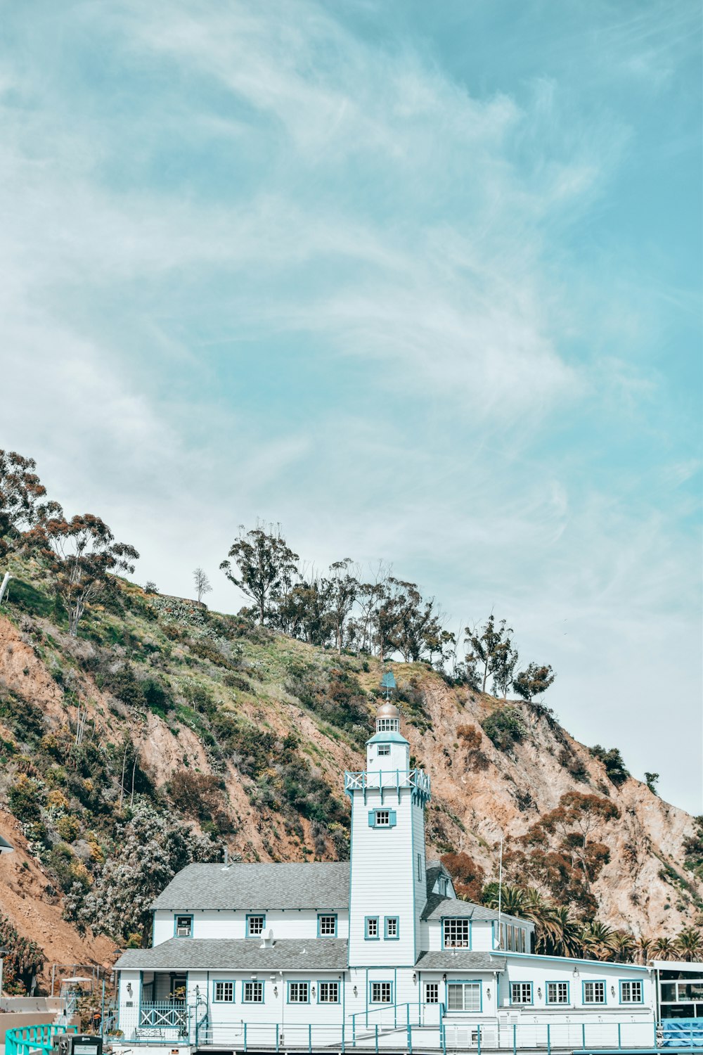 um grande edifício branco sentado no topo de uma colina verde exuberante