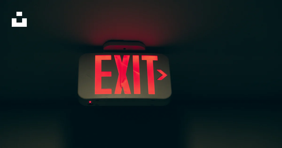 A red exit sign sitting on top of a table photo – Free Sony a6000 Image ...