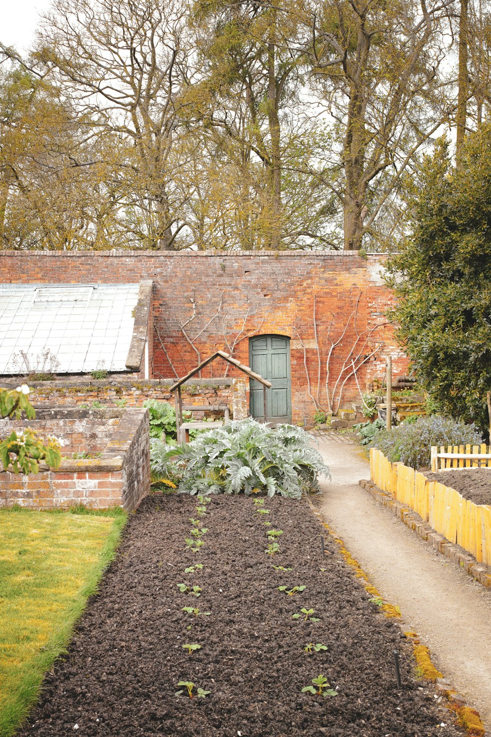 a garden with a brick building in the background