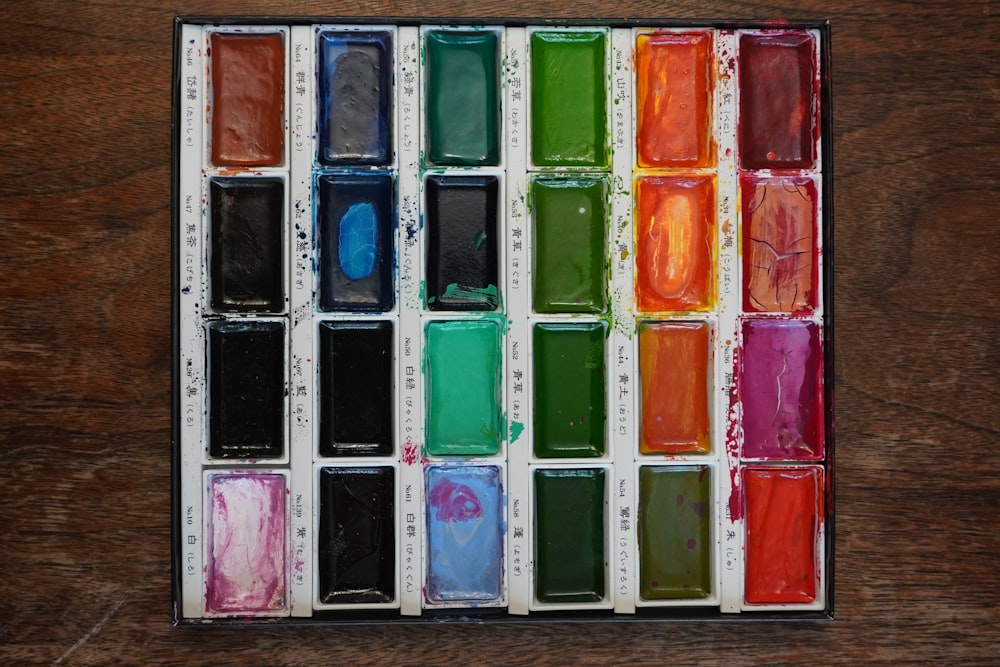 a box of different colors of paint on a table
