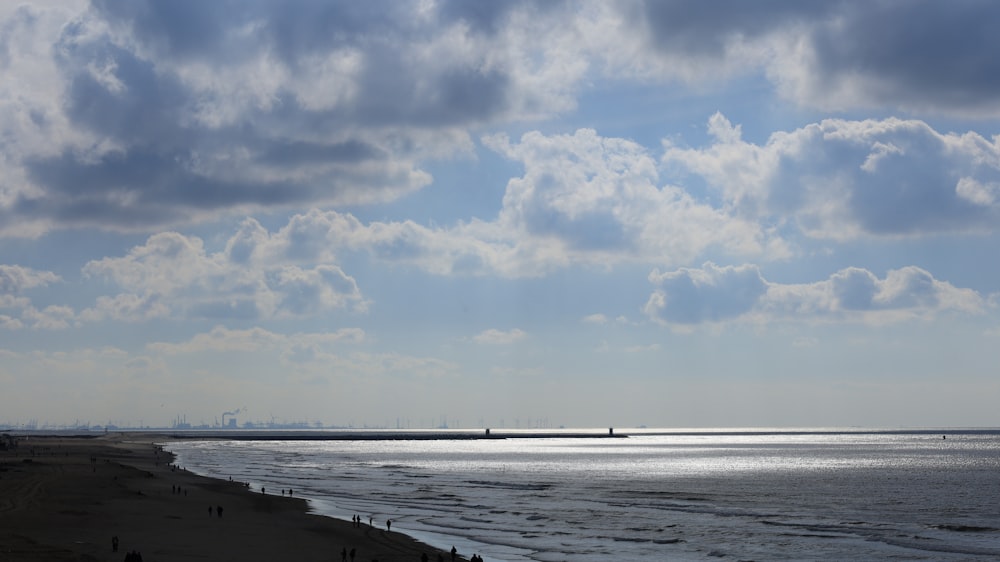 a body of water sitting under a cloudy sky