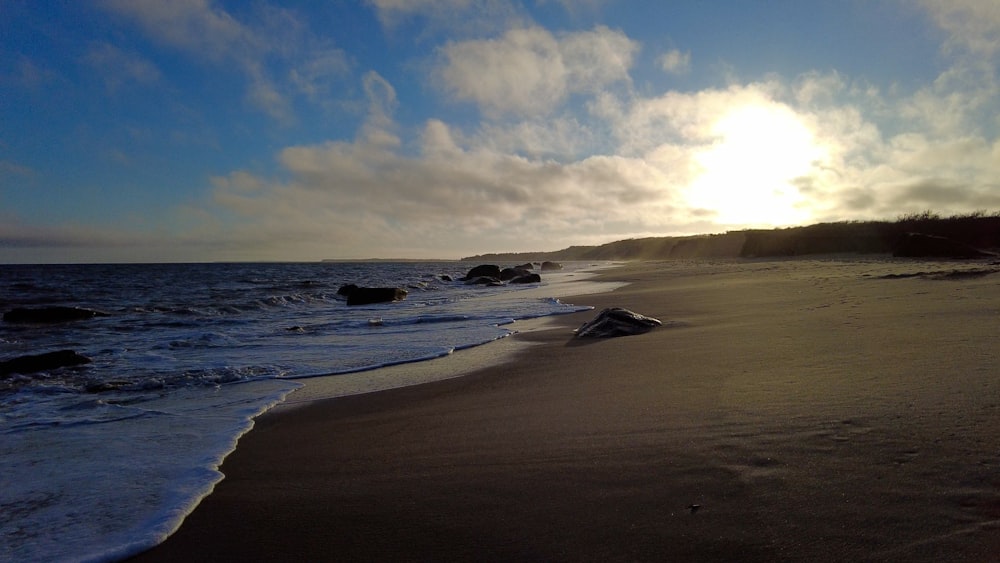 a sandy beach with waves coming in to shore