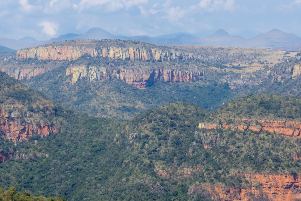 a view of a mountain range with trees and mountains in the background