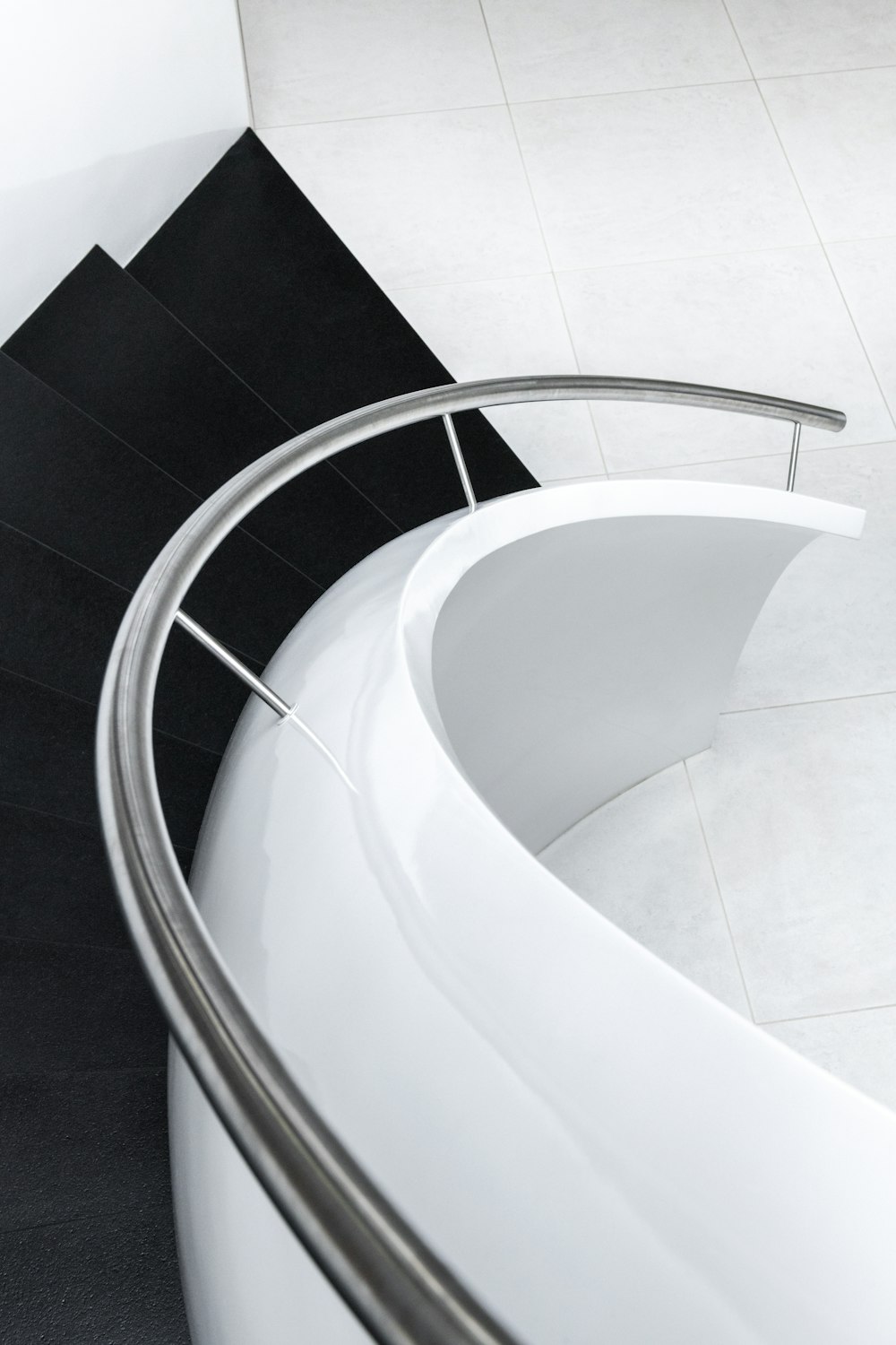 a black and white bathroom with a curved bathtub