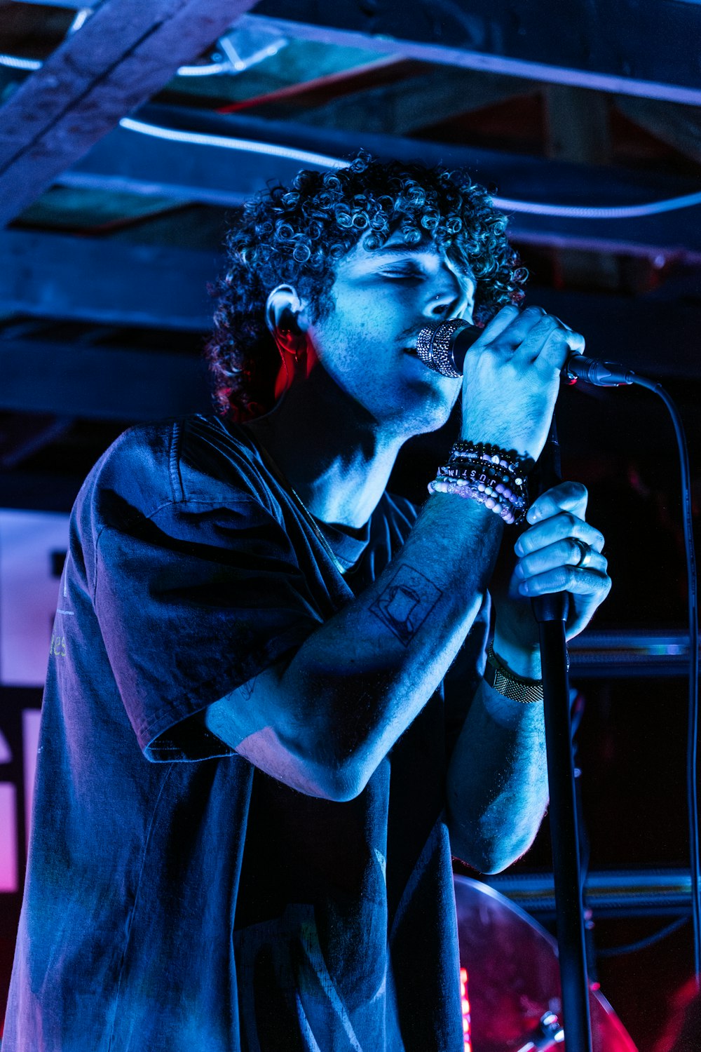 a man singing into a microphone on stage