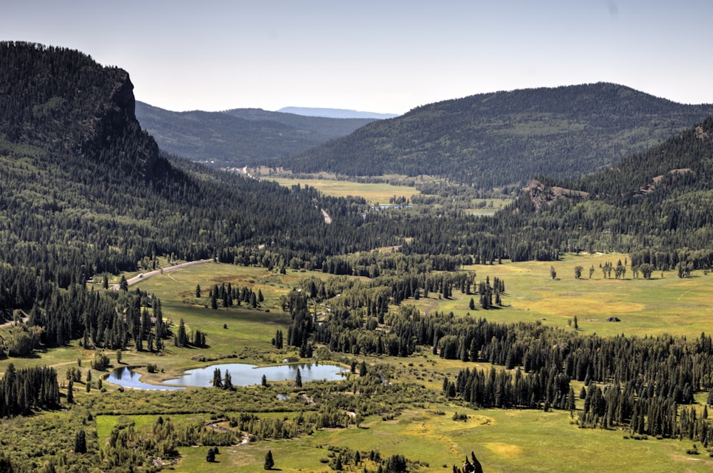 a scenic view of a valley with a lake in the middle