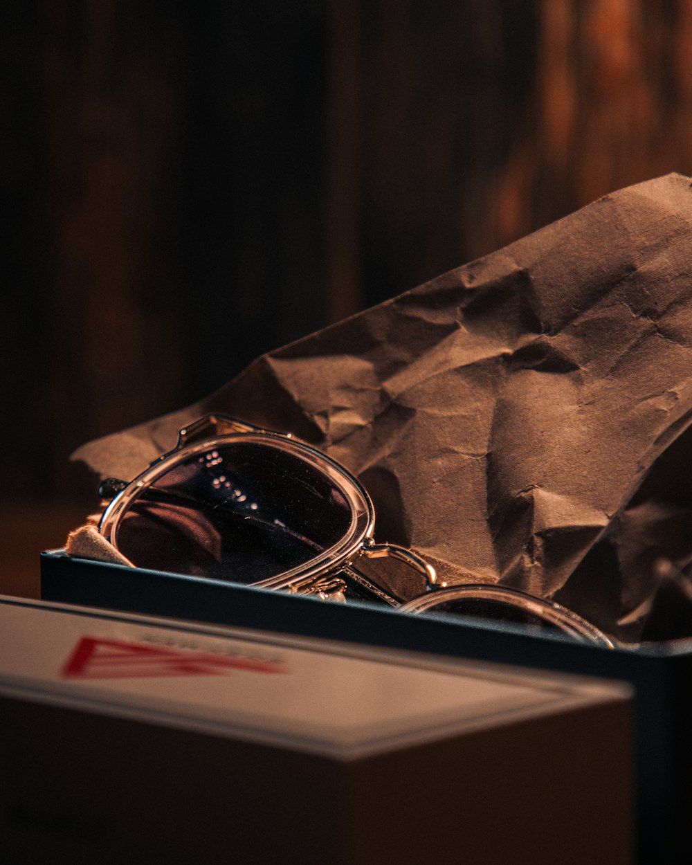 a pair of sunglasses sitting in a brown paper bag