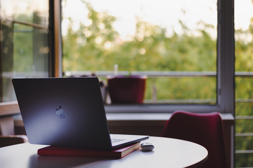 a laptop computer sitting on top of a white table