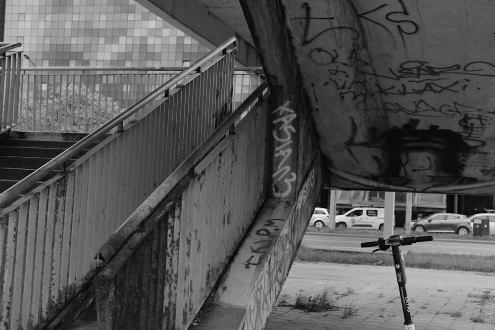 un scooter garé à côté d’un mur avec des graffitis dessus