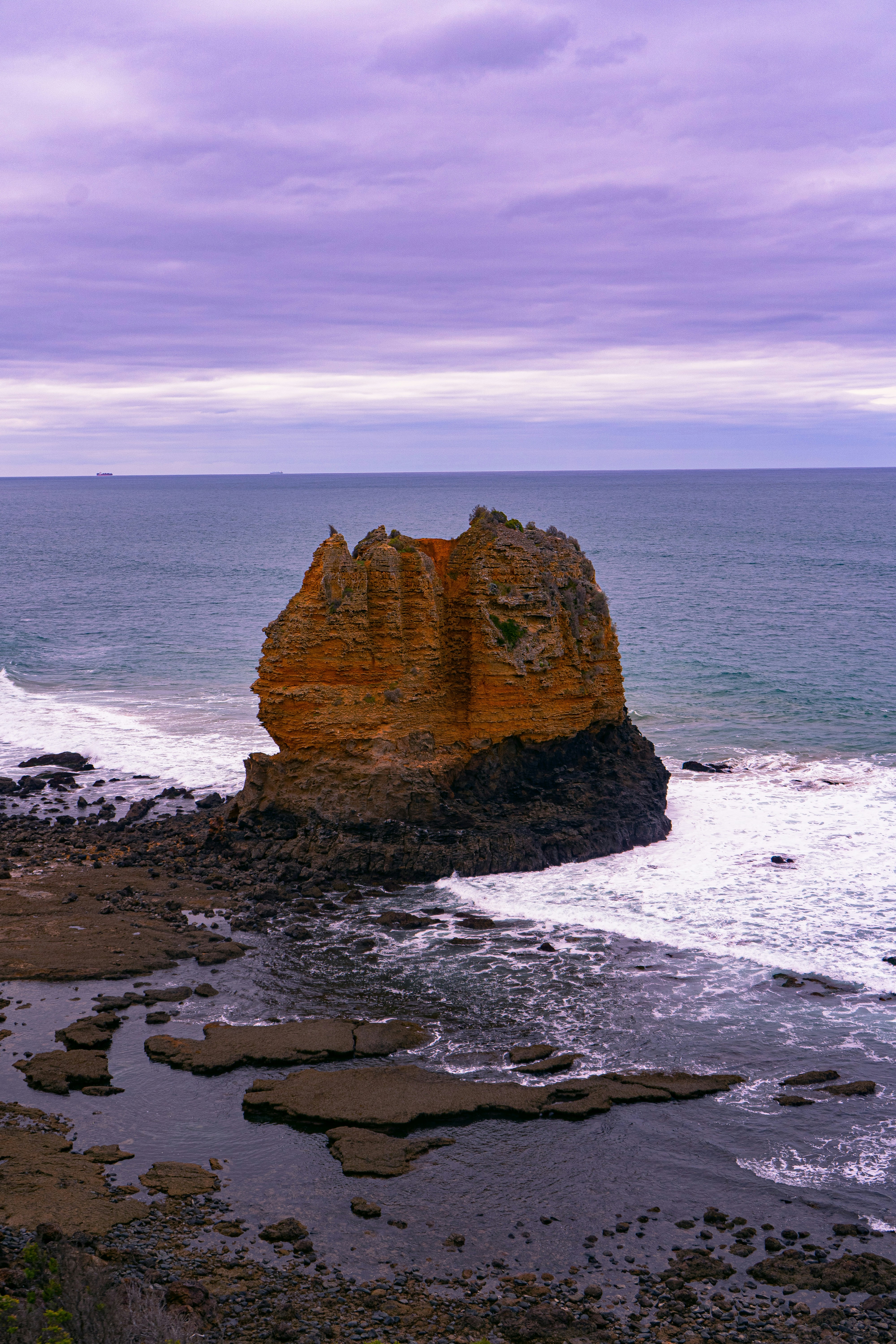 a large rock sticking out of the ocean