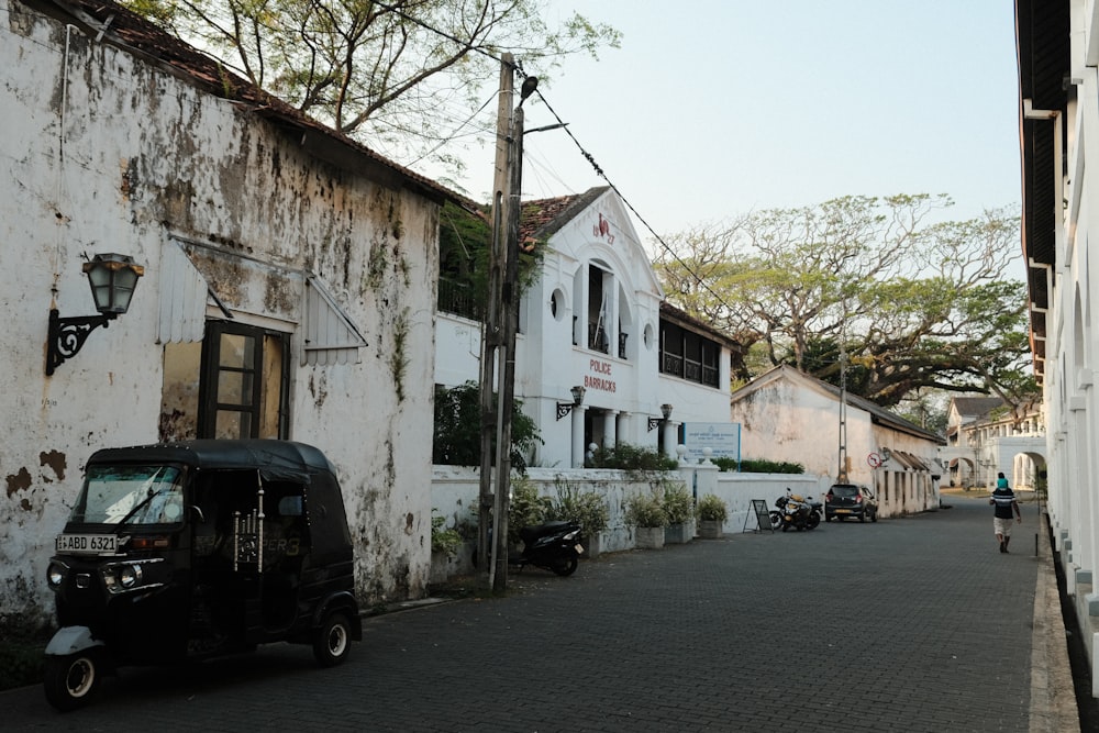 a black scooter parked in front of a white building