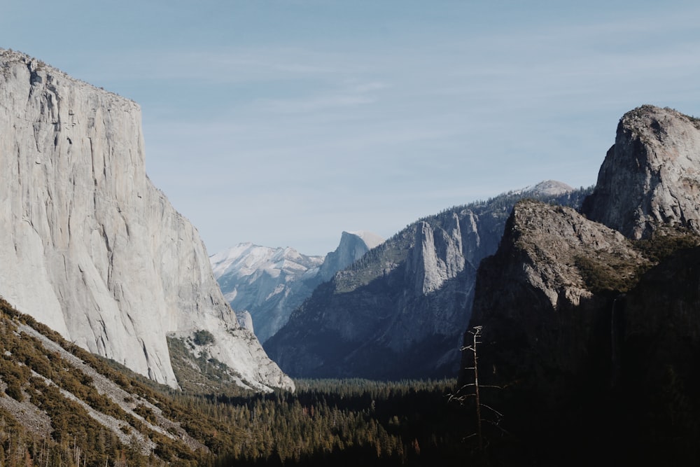 a view of a mountain range with trees and mountains in the background