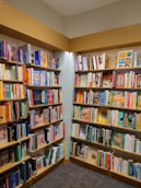 a bookshelf filled with lots of books in a library