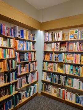 a bookshelf filled with lots of books in a library