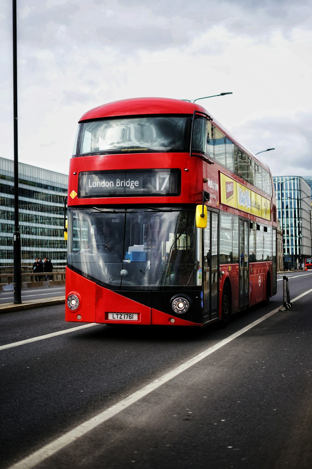 a red double decker bus driving down a street