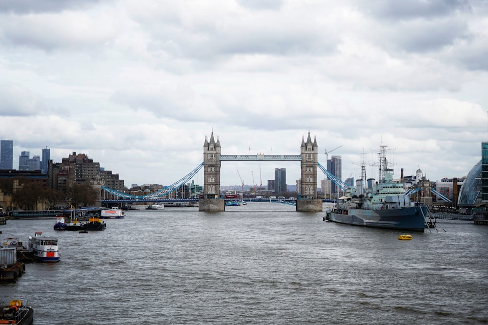 a river with boats and a bridge in the background