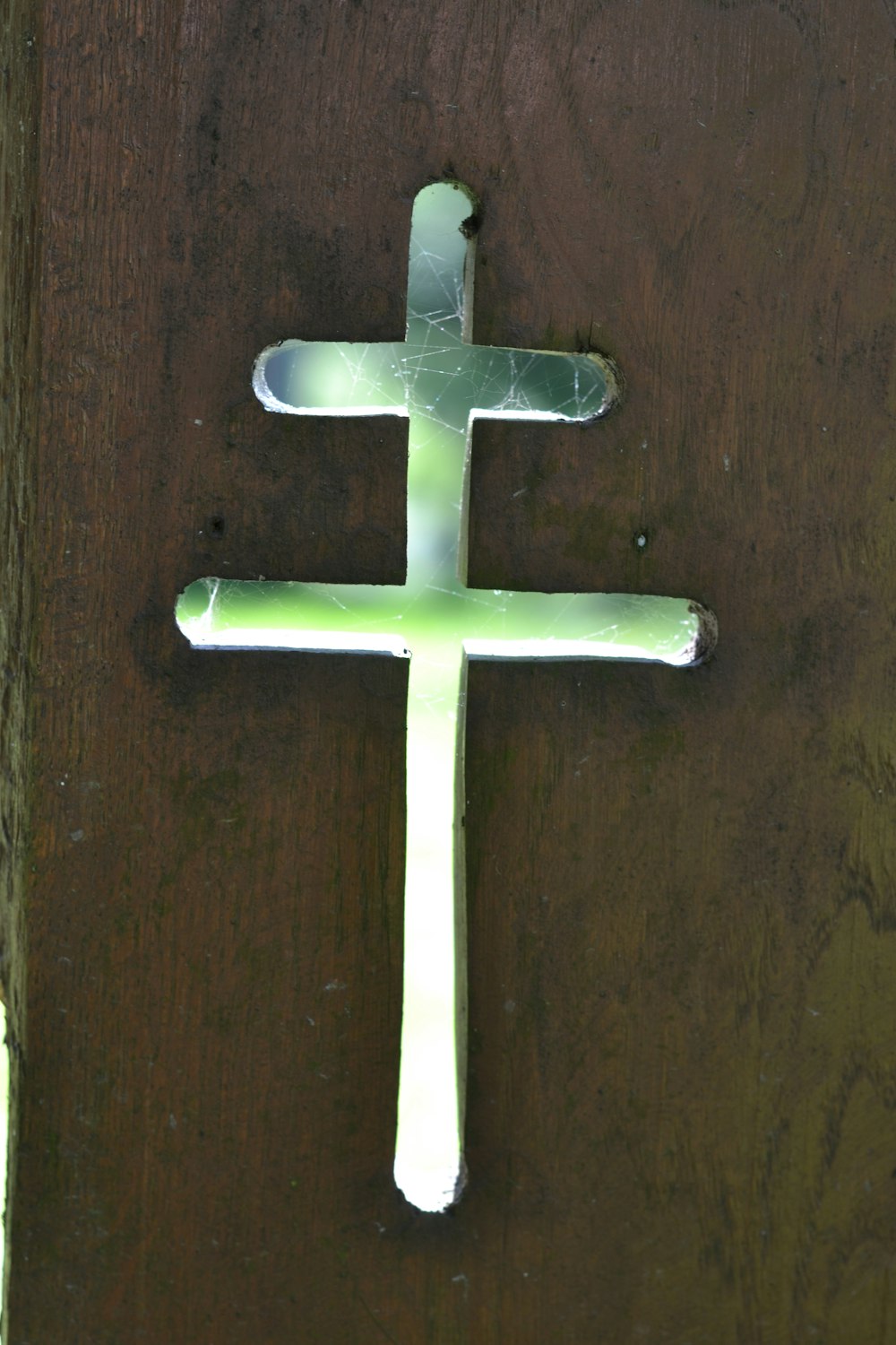 a wooden door with a white cross on it