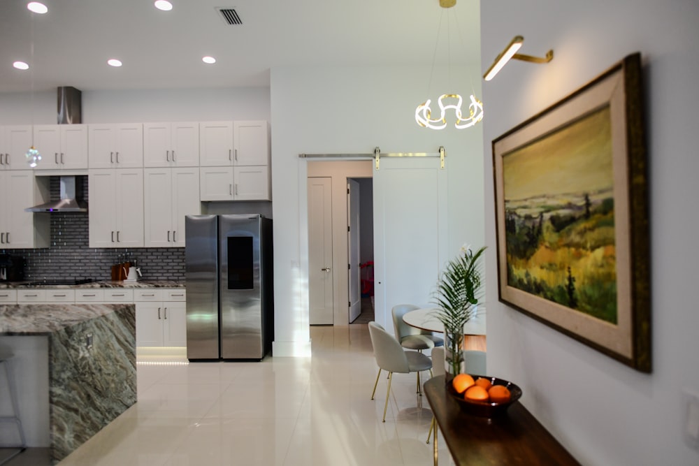 a kitchen with a marble counter top and a painting on the wall