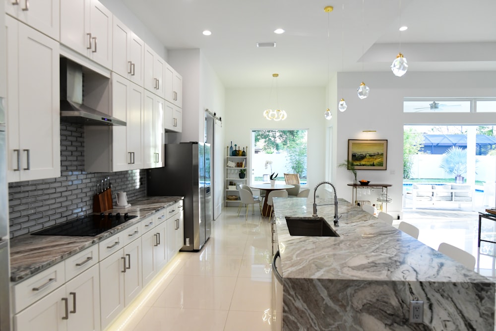 a kitchen with marble counter tops and white cabinets