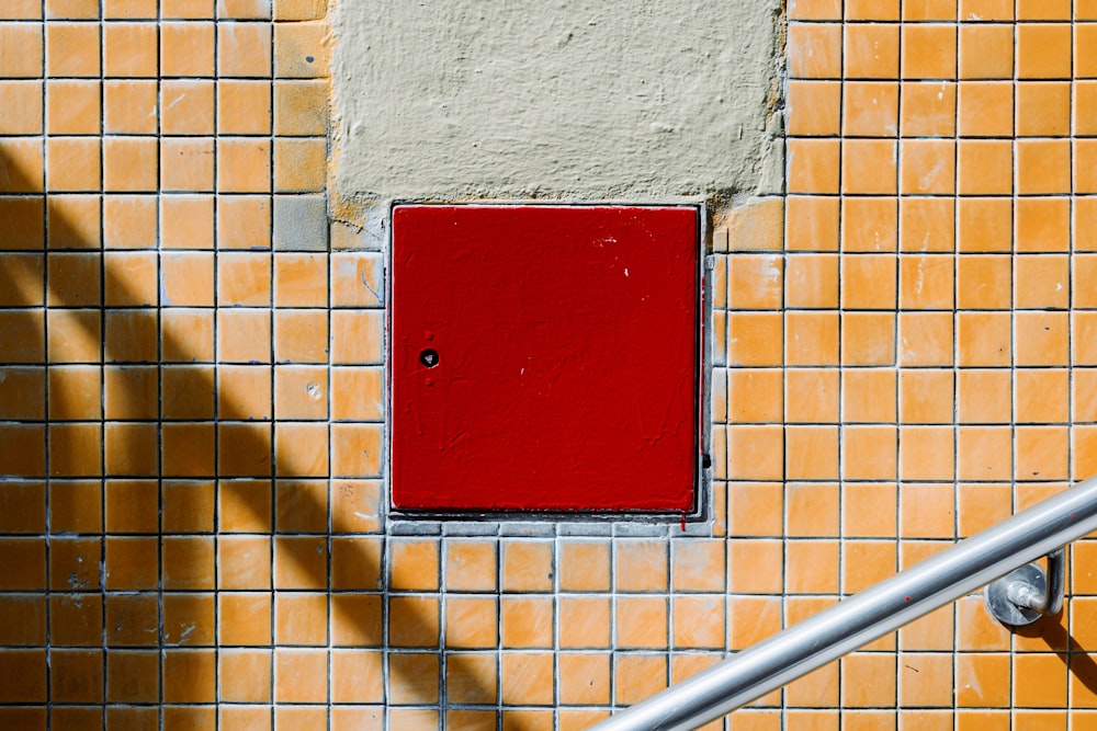 a red square on a yellow and white wall