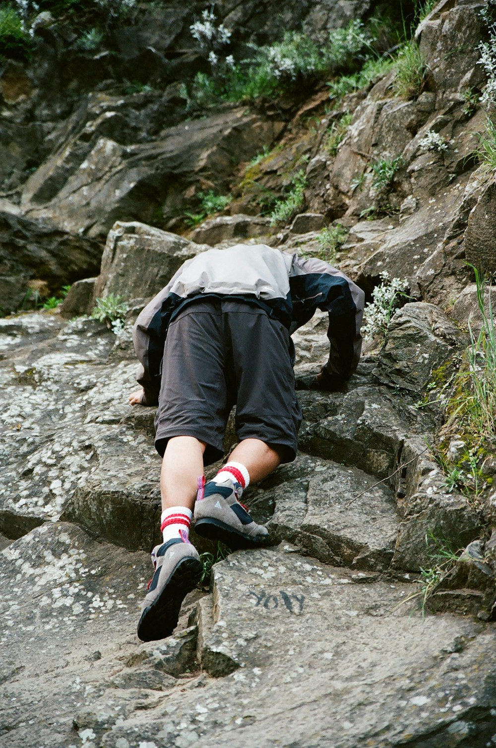 a man laying on top of a rocky hillside