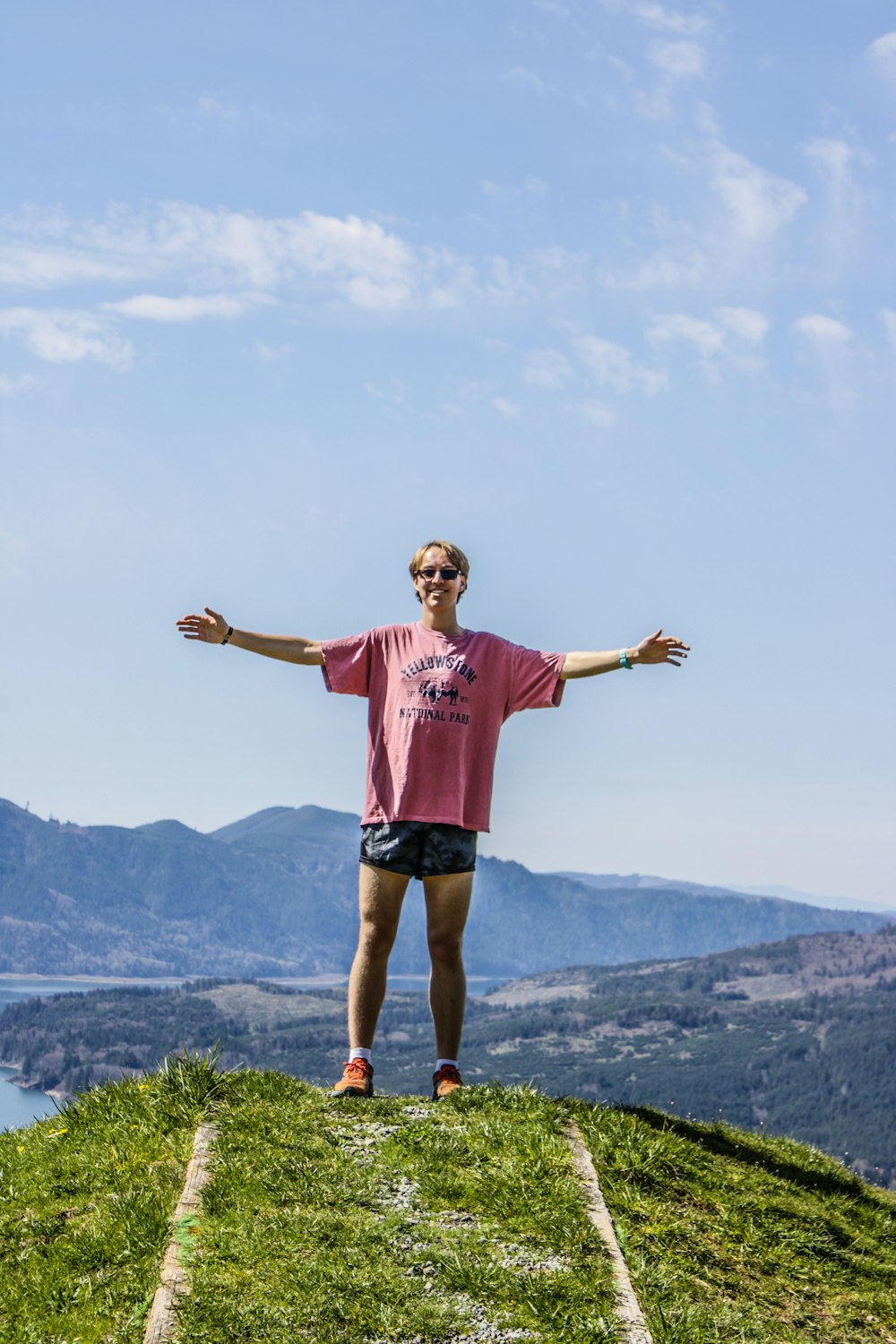 a man standing on top of a lush green hillside