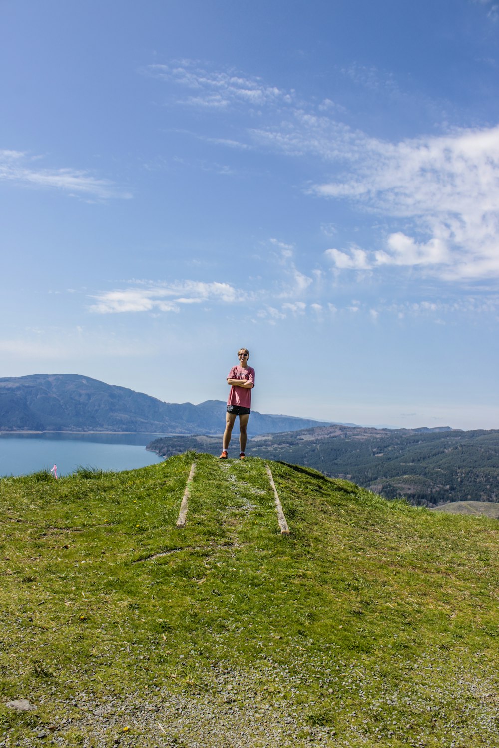 a person standing on top of a grass covered hill