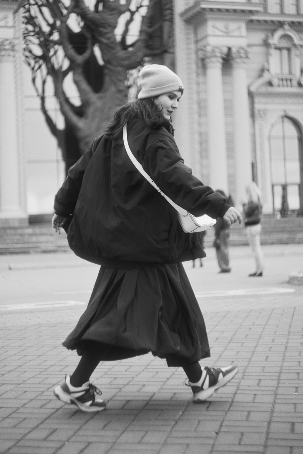 a woman in a long dress is walking down the street