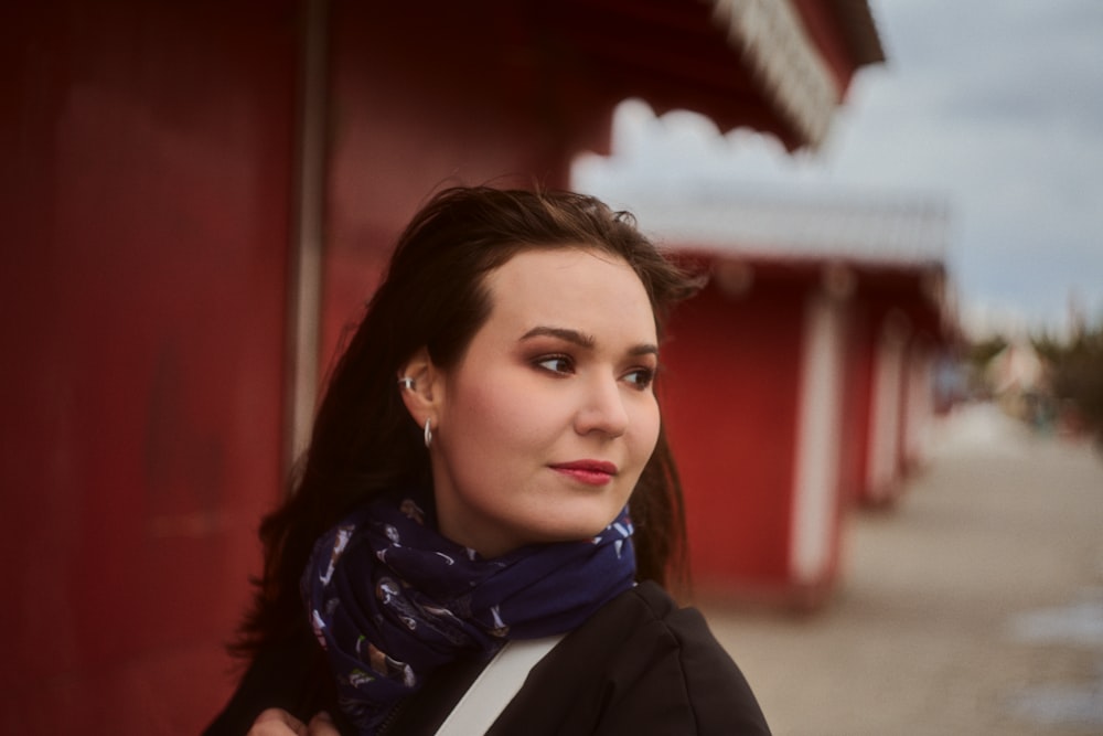 a woman standing in front of a red building