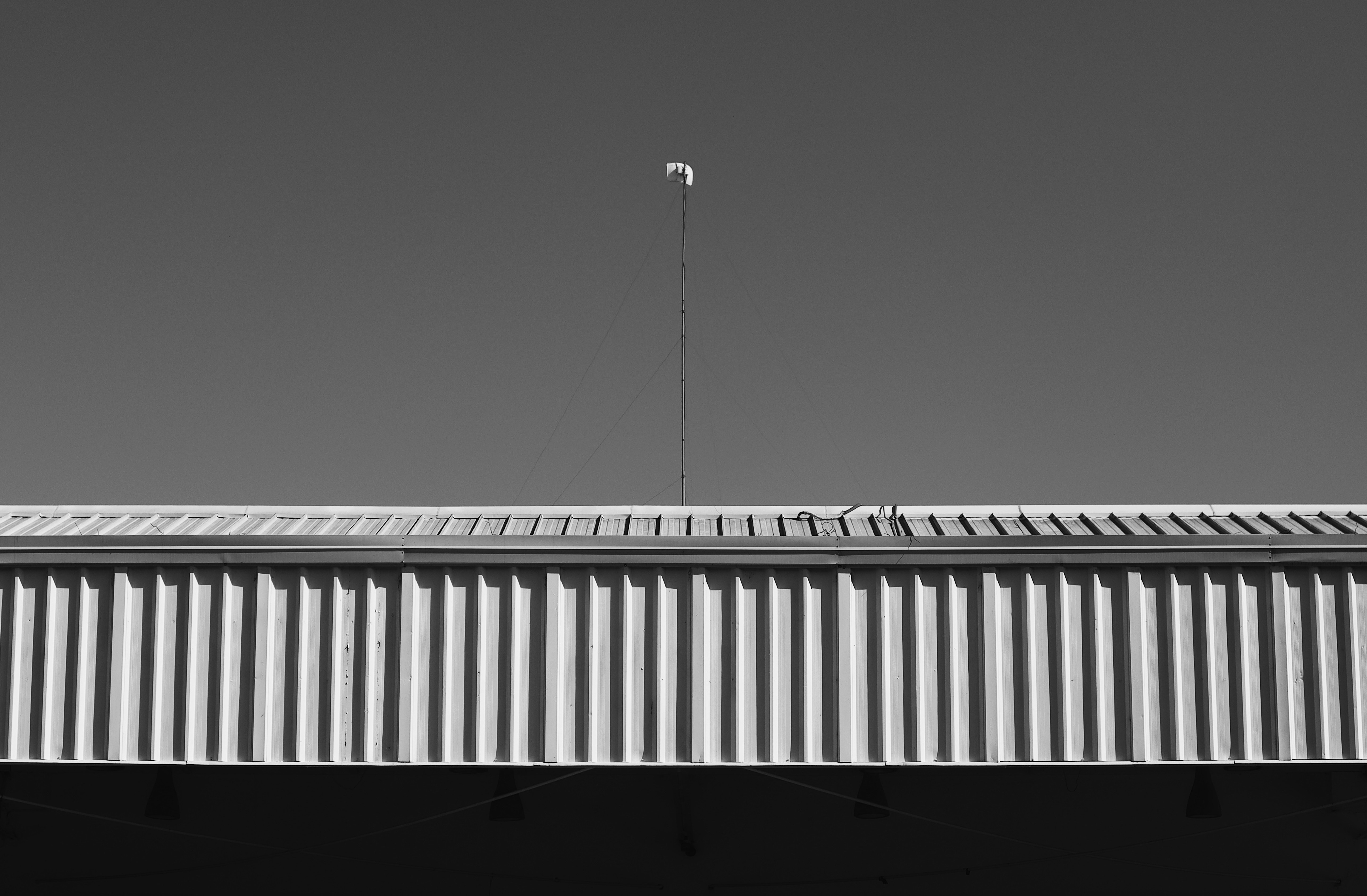 Ein Schwarz-Weiß-Foto eines Flugzeugs, das über ein Gebäude fliegt